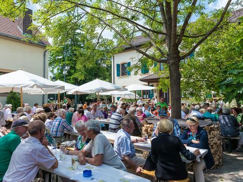 Fröhliche Menschen genießen die Ruppertsberg Kerwe bei einem sonnigen Fest im Freien mit viel Gesellschaft.