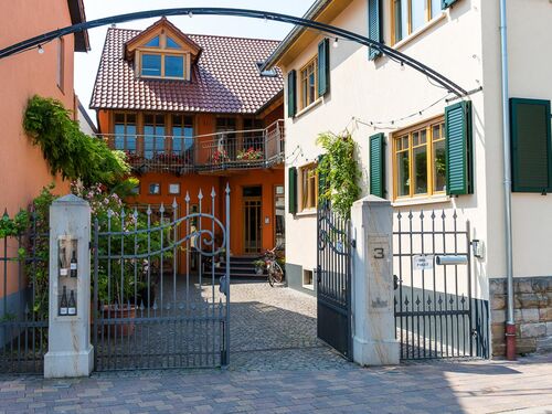 Das stilvolle Eingangstor zu einem charmanten Haus in Niederkirchen mit blühender Vegetation und gemütlichem Ambiente.