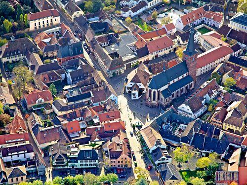 Luftaufnahme mit historischem Ortsbild, in der Mitte eine gotische Kirche