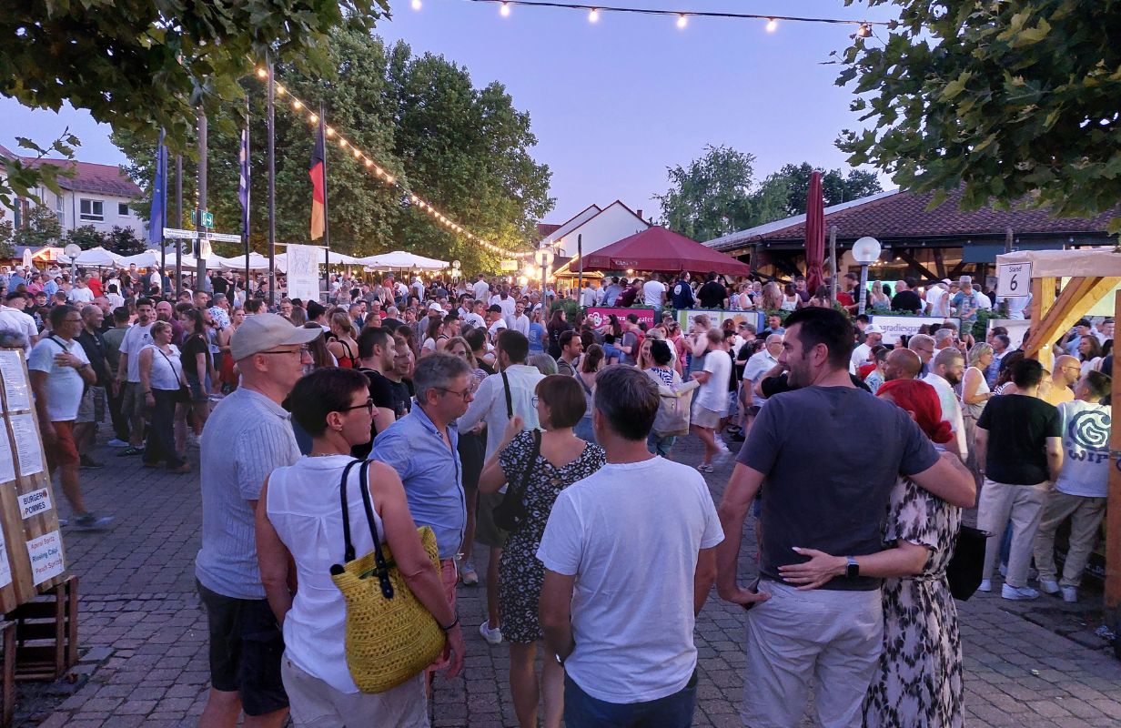 Belebte Atmosphäre beim Deidesheimer Weinkerwe mit vielen Gästen, bunten Lichtern und festlicher Stimmung.