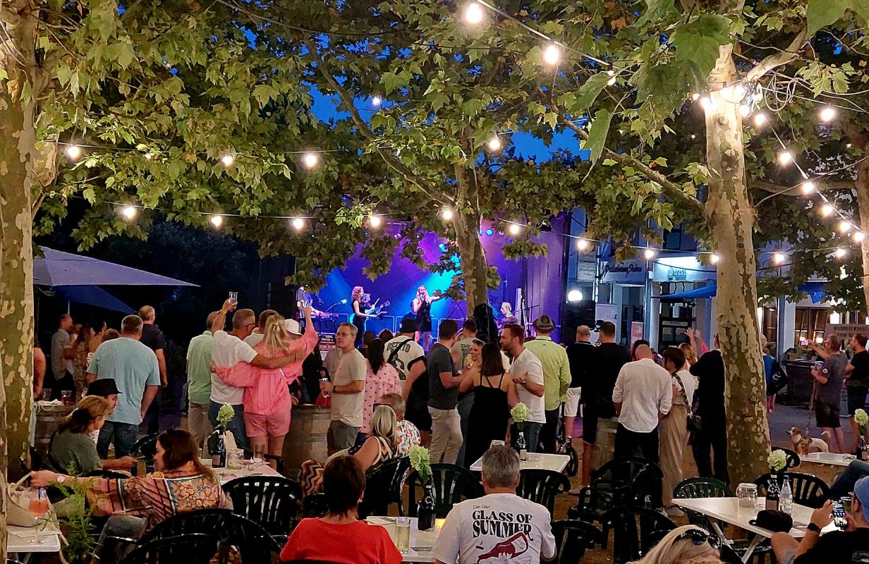 Belebte Atmosphäre bei der Deidesheimer Weinkerwe mit Musik und fröhlichen Gästen unter Lichtern.