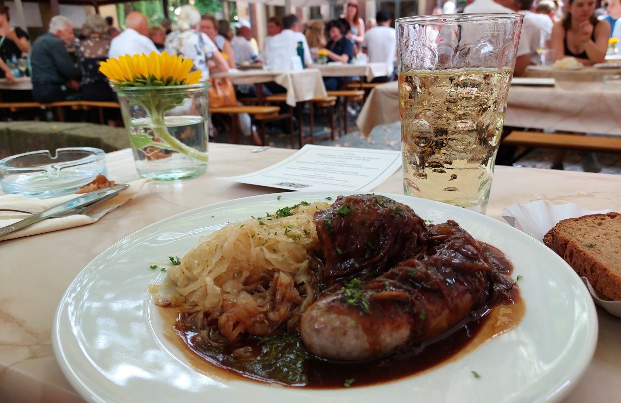 Leckere Sausages mit Sauerkraut und Brot, serviert auf der Deidesheimer Weinkerwe im Freien.