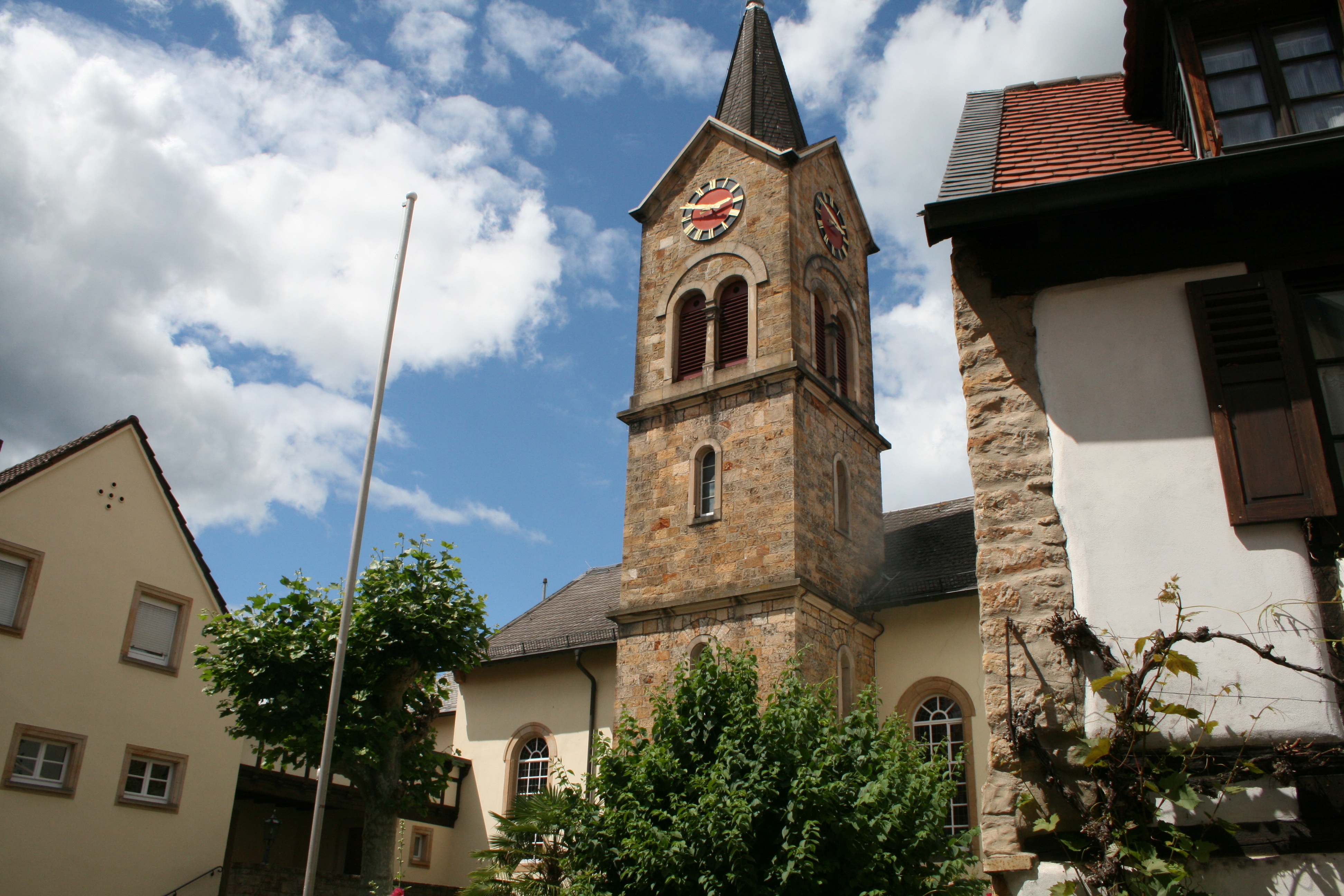 Die protestantische Kirche in Deidesheim erhebt sich majestätisch unter einem bewölkten Himmel.